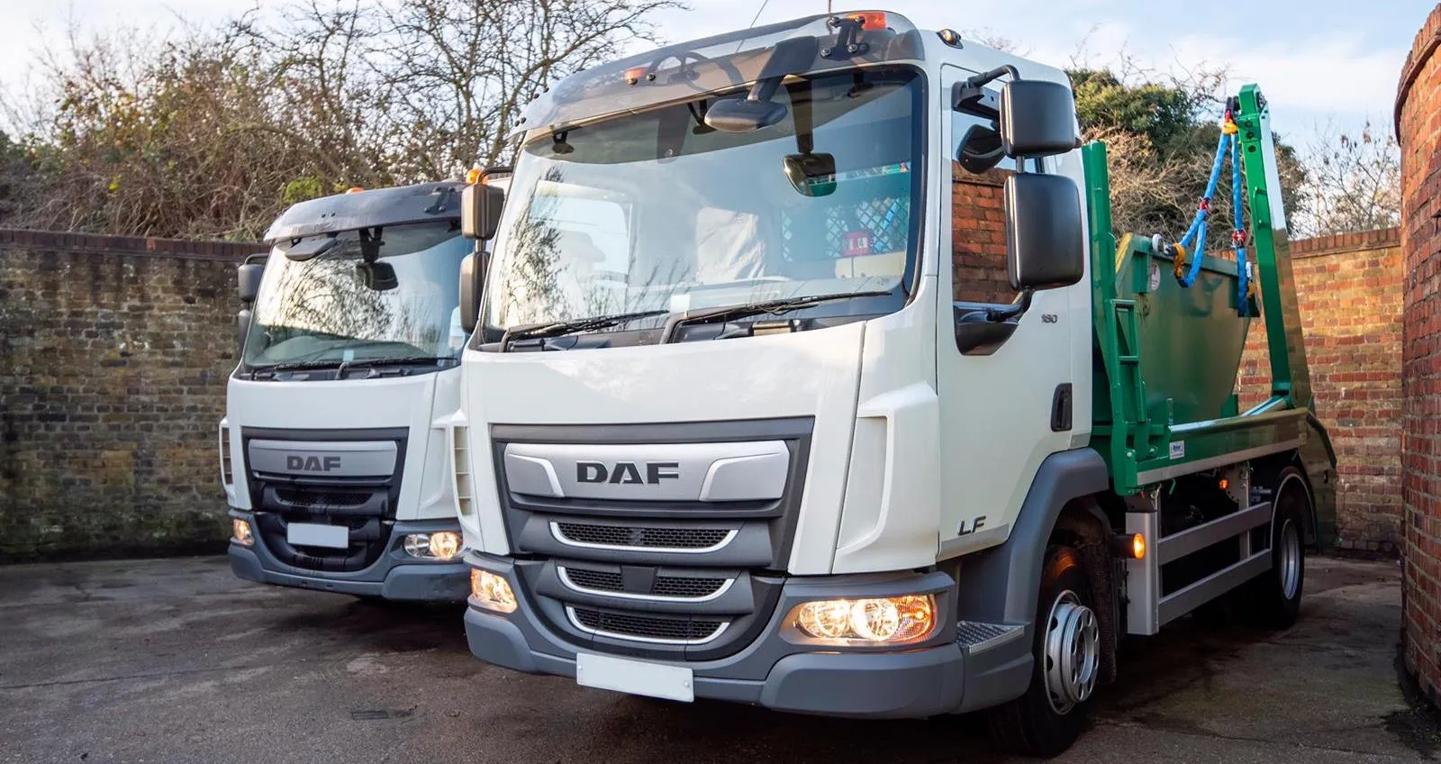 Two A.J. Lucas skip lorries in the yard in Mitcham