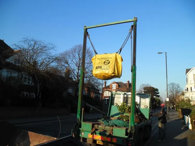 A skip bag being lifted onto a lorry